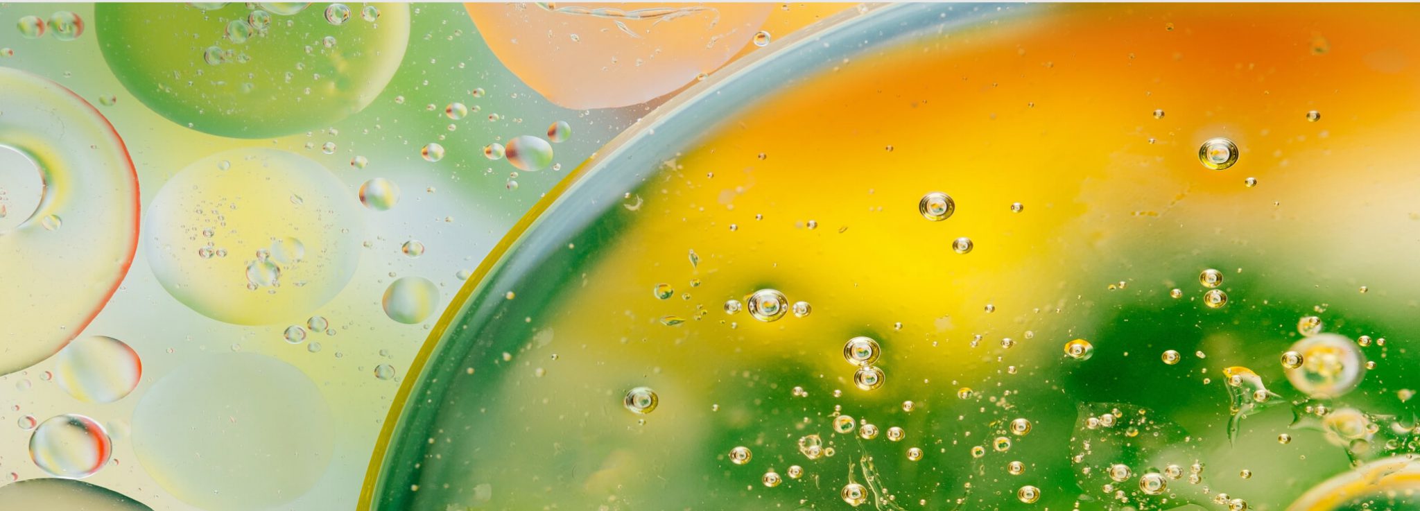 Macro photo of green and yellow liquid droplets combining together